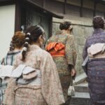 unrecognizable asian women walking on street