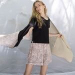 Εσάρπα Root από το brand AMMA με patchwork σχεδιασμό σε γήινες αποχρώσεις, φορεμένη πάνω από nude outfit - styling pose