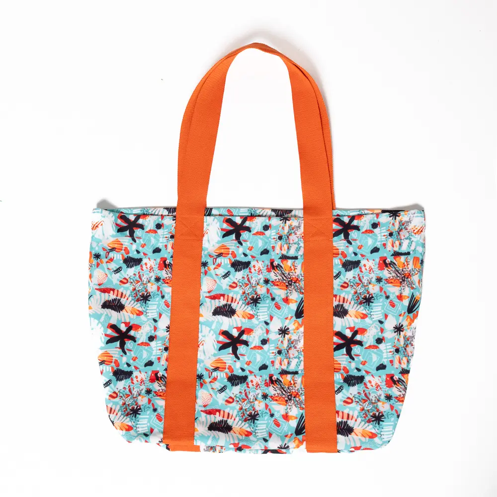 Η Soléa είναι φτιαγμένη για να λάμπει κάτω από τον ήλιο. Το φωτεινό της μοτίβο και τα πορτοκαλί χερούλια συνδυάζονται με εσωτερική αδιάβροχη φόδρα και λεπτομέρεια logo