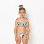 Το Girl’s Ruffled Bikini με το μοτίβο Soléa είναι γεμάτο ενέργεια και φωτεινότητα. Το μπικίνι διαθέτει παιχνιδιάρικα βολάν και ρυθμιζόμενες τιράντες για άνεση και τέλεια εφαρμογή. Από τη συλλογή Sea of Feelings – Vasiliki Swimwear Summer 25