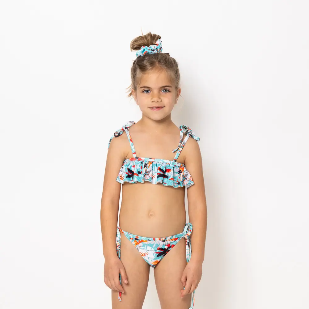 Το Girl’s Ruffled Bikini με το μοτίβο Soléa είναι γεμάτο ενέργεια και φωτεινότητα. Το μπικίνι διαθέτει παιχνιδιάρικα βολάν και ρυθμιζόμενες τιράντες για άνεση και τέλεια εφαρμογή. Από τη συλλογή Sea of Feelings – Vasiliki Swimwear Summer 25